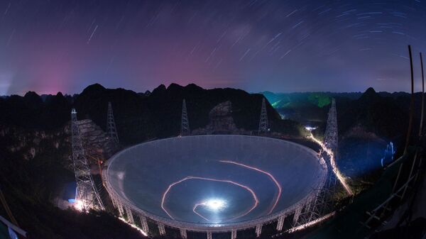Veículo deixa rastros de luz em uma foto de longa exposição sob o Telescópio Esférico de Abertura de 500 metros (FAST) - Sputnik Brasil