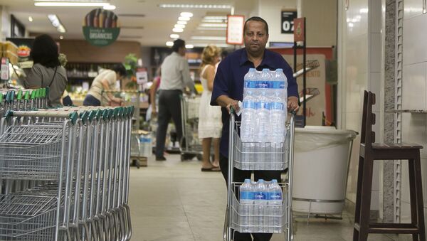 Homem compra água mineral em supermercado em Copacabana, Rio de Janeiro. Residentes do Rio estão preocupados com a qualidade da água. - Sputnik Brasil