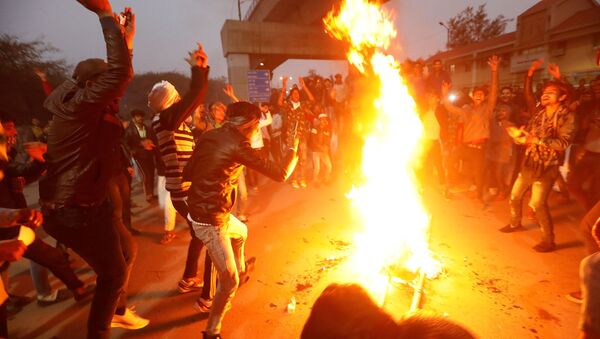 Manifestantes queimam uma efígie representando o primeiro-ministro Narendra Modi durante um protesto contra uma nova lei de cidadania, perto da Universidade Jamia Millia Islamia, em Nova Deli, Índia, em 16 de dezembro de 2019 - Sputnik Brasil