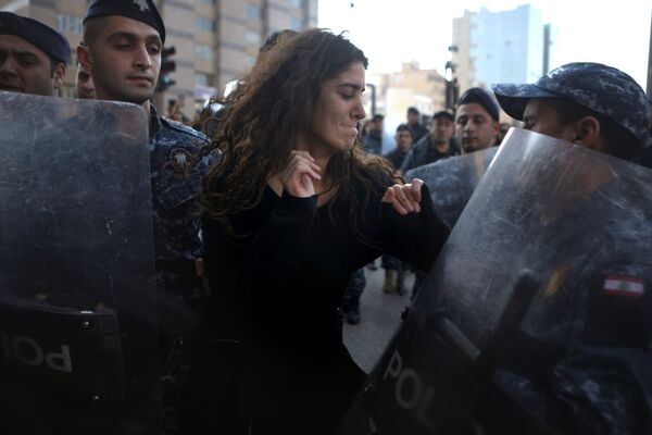 Manifestante e agentes da polícia libanesa em Beirute - Sputnik Brasil