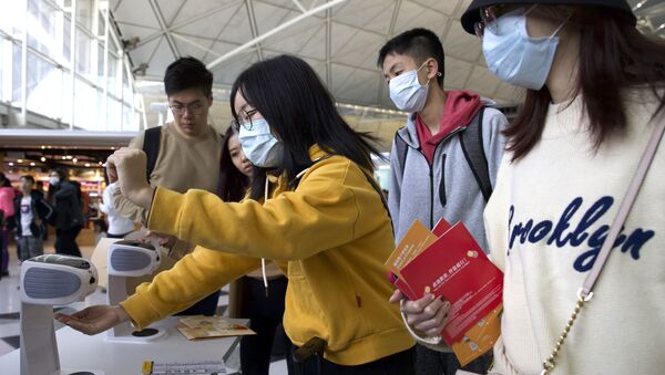 Viajantes higienizam suas mãos no Aeroporto de Hong Kong para evitar contaminações pelo coronavírus da China - Sputnik Brasil
