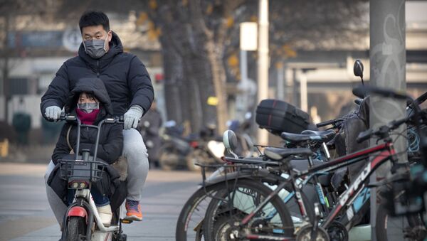 Casal usa máscaras para se proteger do novo coronavírus enquanto passeia de moto em Pequim - Sputnik Brasil