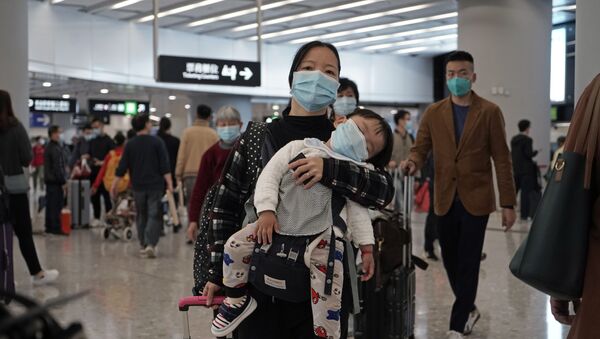 Mãe e filho caminham em aeroporto com máscaras para se proteger do novo coronavírus da China - Sputnik Brasil
