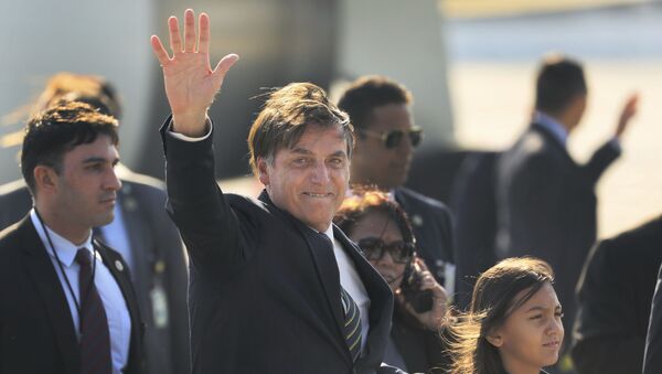 Bolsonaro acena ao chegar no aeroporto de Nova Deli, na Índia. - Sputnik Brasil