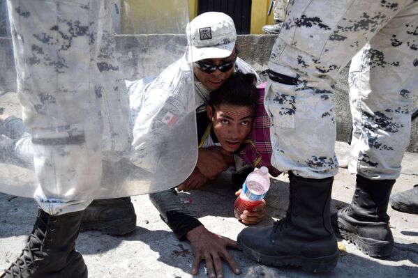 Membro da Guarda Nacional do México prende um imigrante, que tentava atravessar fronteira rumo aos EUA
 - Sputnik Brasil