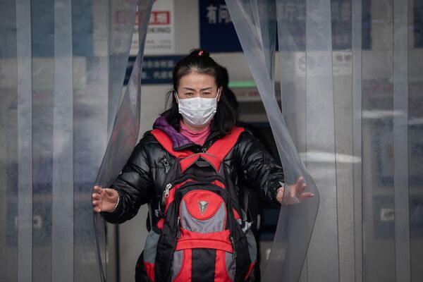 Em estação de trem em Pequim, chinesa usa uma máscara para evitar se contaminar pelo coronavírus, em 27 de janeiro de 2020  - Sputnik Brasil