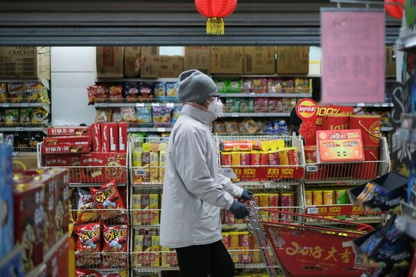 Uma mulher utiliza máscara de proteção enquanto faz compras em um supermercado, em Pequim, na China, em 26 de janeiro de 2020 - Sputnik Brasil