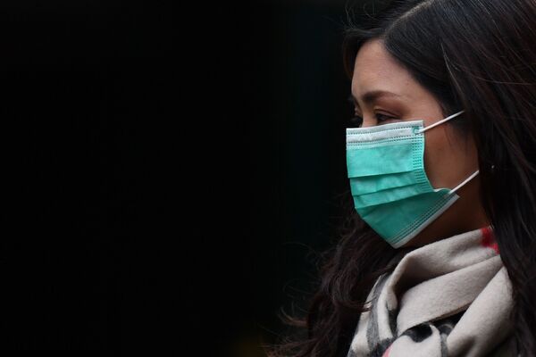 Garota usa máscara de proteção no bairro tradicional chinês de Londres, China Town, no Reino Unido, em 24 de janeiro de 2020 - Sputnik Brasil