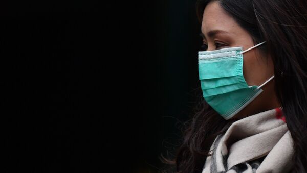 Mulher em uma máscara cirúrgica em uma Chinatown em Londres - Sputnik Brasil