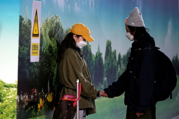 Casal usa máscara de proteção no aeroporto de Pudong, em Xangai, na China, em 27 de janeiro de 2020 - Sputnik Brasil