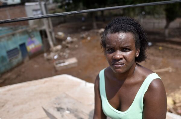 Maria Aparecida, que foi carregada pelo filho quando o rio alagou sua casa, se senta em telhado em Minas Gerais - Sputnik Brasil