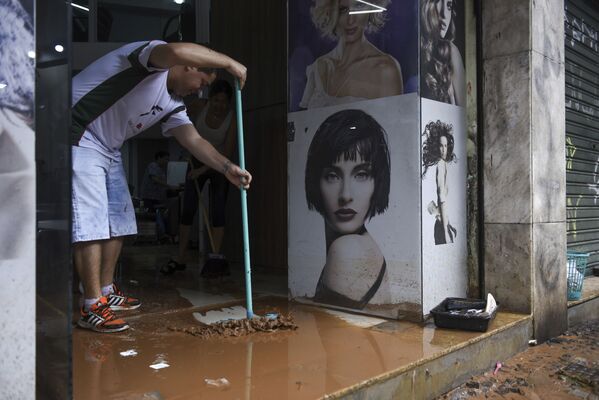 Homem limpa loja alagada durante fortes chuvas em Belo Horizonte - Sputnik Brasil