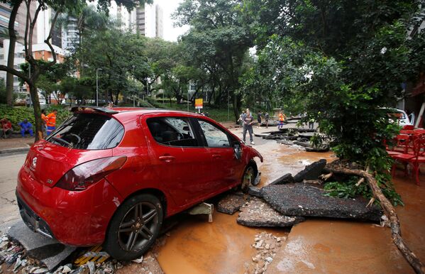 Carro vermelho em meio aos destroços de uma rua em Belo Horizonte - Sputnik Brasil
