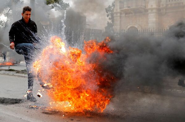 Manifestante palestino chuta pneu em chamas durante protesto realizado em Belém contra o plano de Trump - Sputnik Brasil