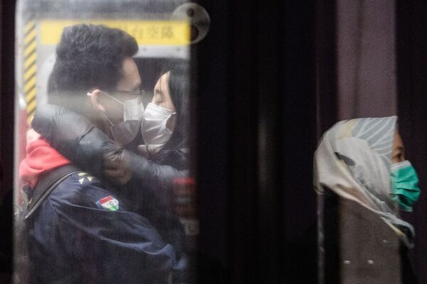 Casal tenta se beijar enquanto usam máscaras no metrô de Hong Kong - Sputnik Brasil