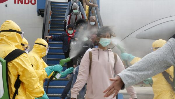 Médicos borrifam cidadãos indonésios com antisséptico após serem evacuados de cidade epicentro de surto de coronavírus na China, Wuhan - Sputnik Brasil
