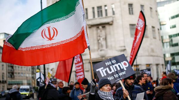 Manifestante ergue a bandeira iraniana durante um protesto em oposição à ameaça de guerra contra o Irã em Londres, Reino Unido - Sputnik Brasil