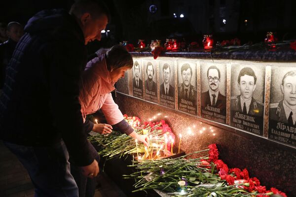 Pessoas colocam flores e acendem velas durante homenagem aos liquidatários e vítimas do acidente de Chernobyl na cidade de Slavutich - Sputnik Brasil