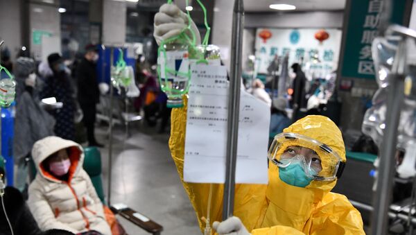 Funcionário hospitalar protegido aplica medicamento em hospital em meio a surto do novo coronavírus em Wuhan, província de Hubei, China, 3 de fevereiro de 2020 - Sputnik Brasil