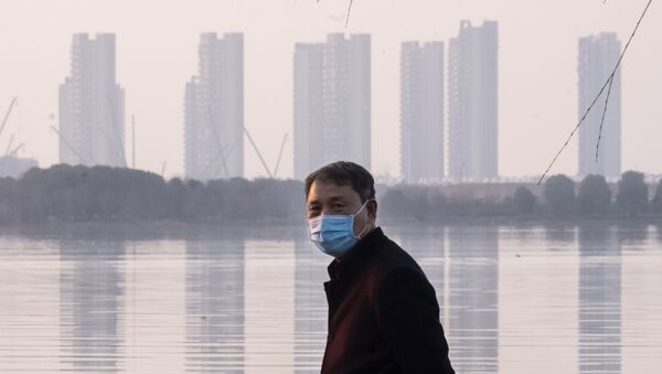 Homem usa máscara para se proteger do coronavírus, em Wuhan, na China, em 30 de janeiro de 2020 - Sputnik Brasil