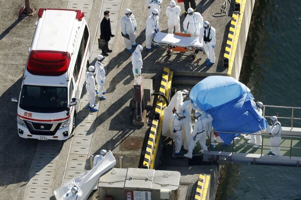 Paciente com coronavírus (coberto com lençol azul) é transferido do navio de cruzeiro Diamond Princess para uma base policial marítima japonesa - Sputnik Brasil