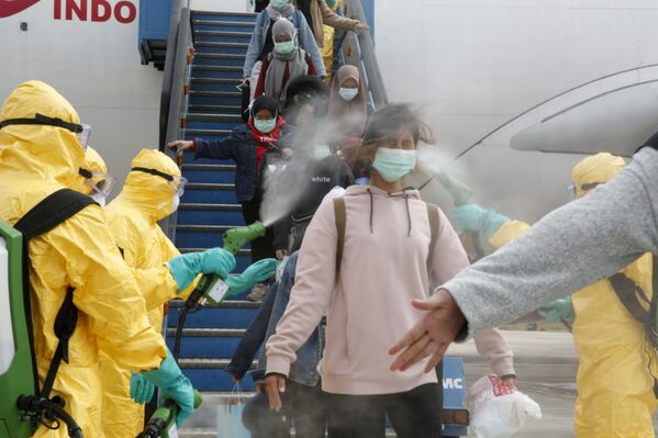 Agentes da Saúde da Indonésia usam borrifador antisséptico em passageiros de voo oriundo da cidade chinesa de Wuhan - Sputnik Brasil