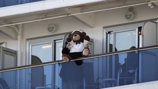 Mulher segura urso de pelúcia no balcão do cruzeiro Diamond Princess - Sputnik Brasil