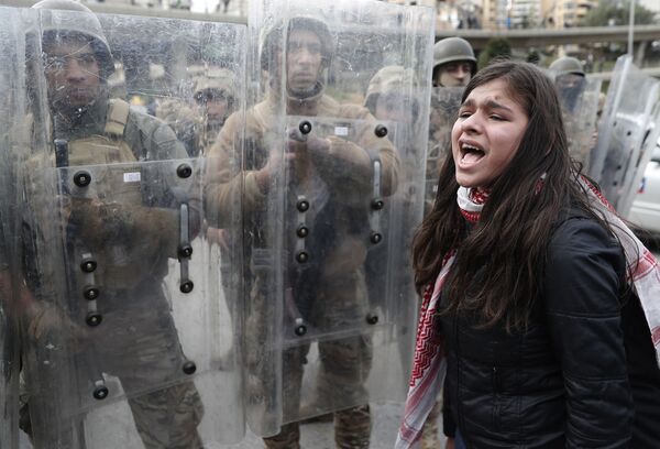 Jovem grita slogans durante protestos contra o governo libanês diante de soldados do país perto do prédio do parlamento local, na capital Beirute - Sputnik Brasil