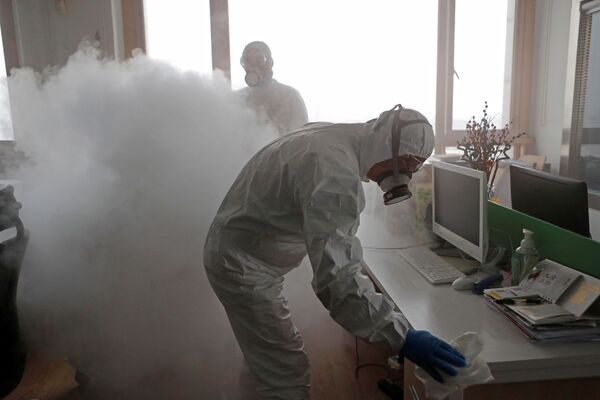Funcionários descontaminam um escritório em Xangai após surto do coronavírus na China - Sputnik Brasil