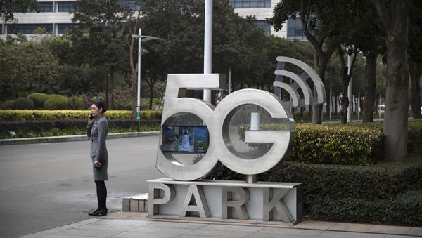 Funcionária da Huawei fala ao celular em escritório da empresa em Shenzhen, na China, em dezembro de 2019 - Sputnik Brasil