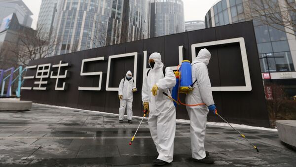 Trabalhadores protegidos desinfectam complexo comercial, após surto do novo coronavírus no país, Pequim, China, 13 de fevereiro de 2020 - Sputnik Brasil