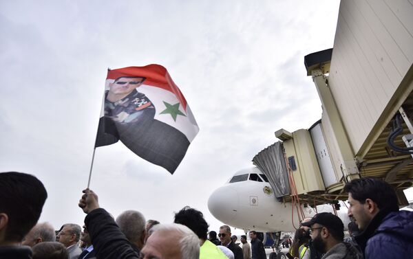 Homem levanta bandeira da Síria com imagem de Bashar Assad - Sputnik Brasil