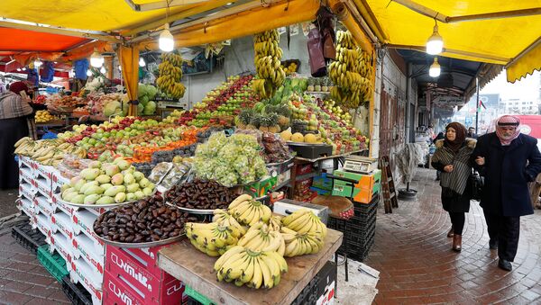 Palestinos caminham ao lado de barraca de frutas em mercado de Ramallah, na Cisjordânia - Sputnik Brasil