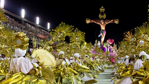 Ala das baianas com carro alegórico, ao fundo, representando um Jesus negro morto a tiros. A representação foi destaque do desfile de 2020 da Mangueira no Rio de Janeiro. - Sputnik Brasil