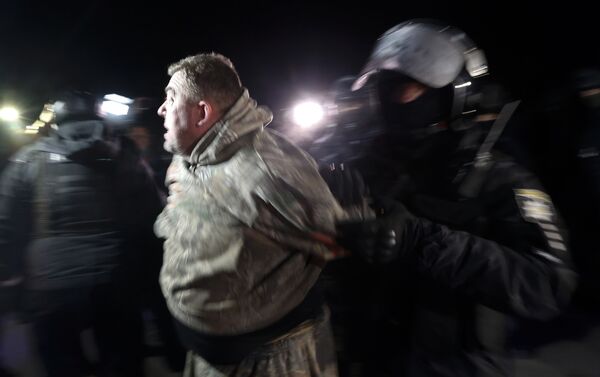 Polícia ucraniana prende manifestante durante protestos violentos na cidade de Novye Sarzhany, na Ucrânia, em 20 de fevereiro de 2020 - Sputnik Brasil