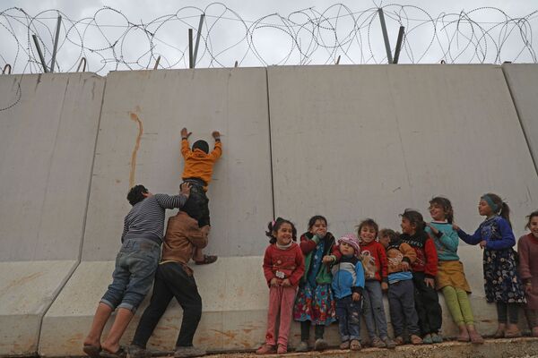 Crianças sírias tentam alcançar topo de muro na fronteira entre a Síria e a Turquia - Sputnik Brasil