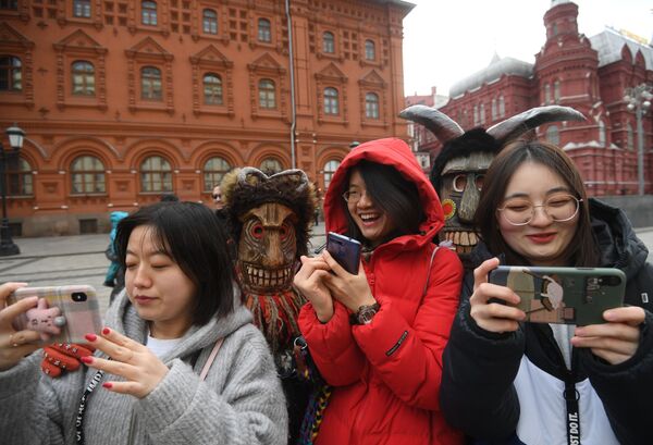 Turistas tiram fotos durante os festejos do tradicional Carnaval russo (Maslenitsa) na praça Manezhnaya em Moscou, Rússia - Sputnik Brasil