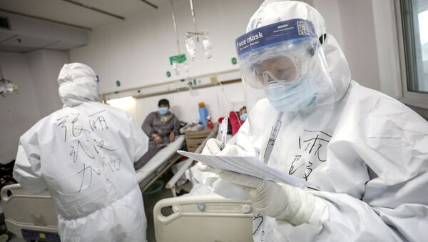 Médicos protegidos verificam registros de paciente no hospital de Jinyintan em Wuhan, o epicentro do novo surto de coronavírus, na província de Hubei, China, 13 de fevereiro de 2020 - Sputnik Brasil
