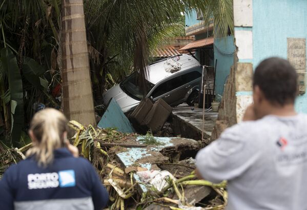 Carro quase de cabeça para baixo em quintal de casa no bairro de Realengo após fortes chuvas atingirem o local - Sputnik Brasil