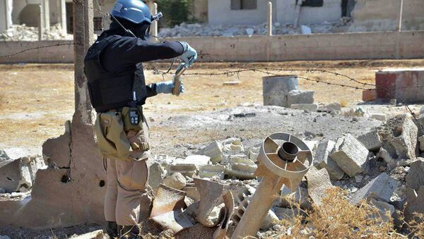 Member of UN investigation team taking samples of sands near a part of a missile that is likely to be one of the chemical rockets according to activists, in Damascus countryside of Ain Terma, Syria - Sputnik Brasil