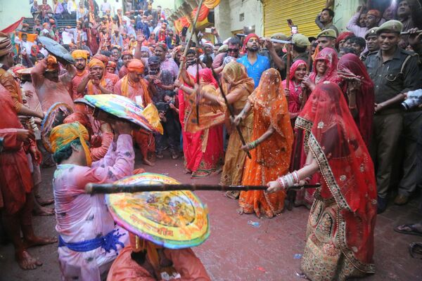 Mulheres batem em homens com uma vara durante as comemorações do festival hindu Lathmar, em 4 de março de 2020 - Sputnik Brasil