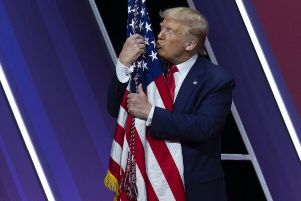 Presidente dos EUA e candidato à reeleição, Donald Trump, beija a bandeira americana após discurso, em 29 de fevereiro de 2020 - Sputnik Brasil