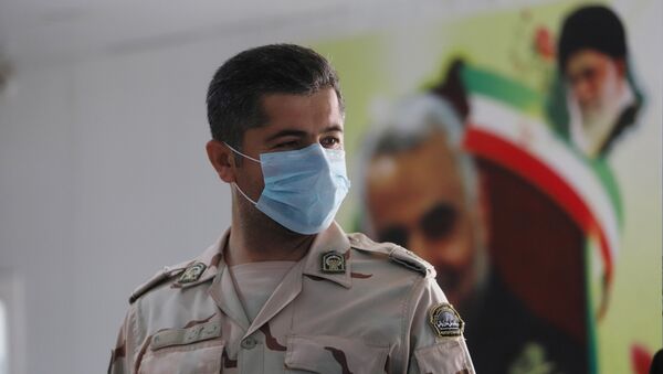 Membro da guarda fronteiriça do Irã usa máscara para se proteger do surto de coronavírus no país - Sputnik Brasil