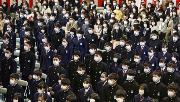 Estudantes usando máscaras protetoras após surto da doença coronavírus (COVID-19), participam da cerimônia de formatura em uma escola de ensino médio em Osaka, no oeste do Japão, 13 de março de 2020 - Sputnik Brasil