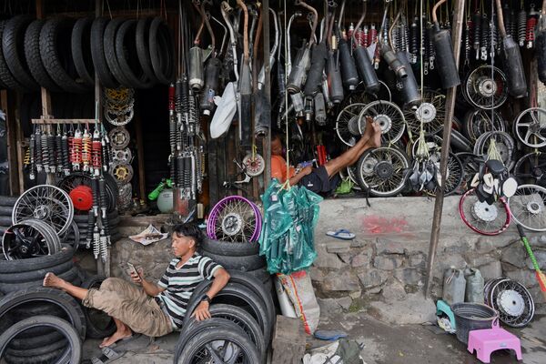 Indonésios esperam clientes em sua oficina de motocicletas na capital Jacarta - Sputnik Brasil