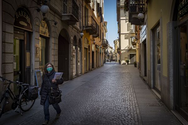 Mulher caminha com máscara em uma das ruas da comuna italiana de Novara - Sputnik Brasil
