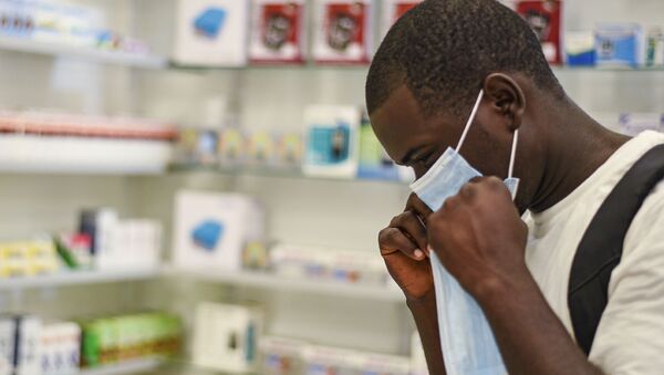 Jovem experimenta máscara de proteção em farmácia na cidade de Kitwe, na Zâmbia - Sputnik Brasil