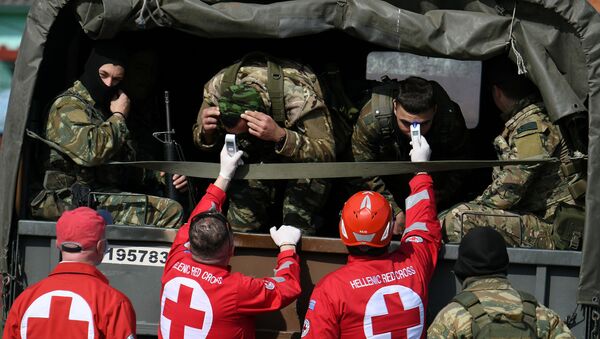 Funcionários da Cruz Vermelha da Grécia checam temperatura de soldados gregos na fronteira com a Turquia, em 15 de março de 2020 - Sputnik Brasil