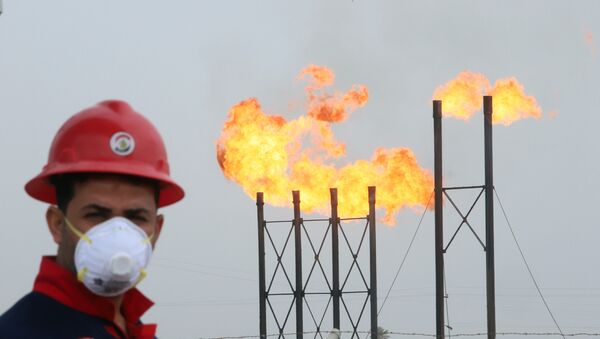 Funcionário usa máscara protetora em poço de petróleo no Iraque, em 15 de março de 2020 - Sputnik Brasil