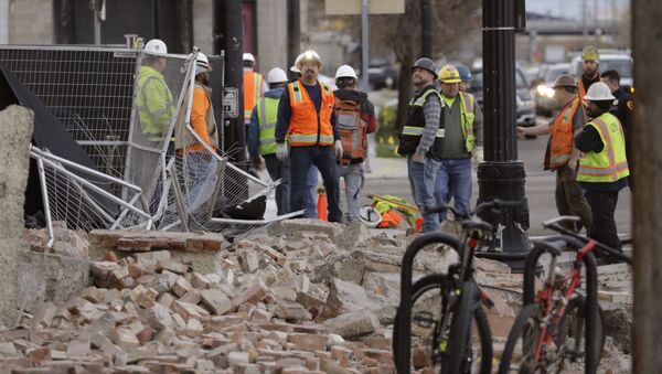 Trabalhadores observam destroços de construção em Salt Lake City após terremoto de magnitude 5,7 atingir o estado de Utah, nos EUA - Sputnik Brasil